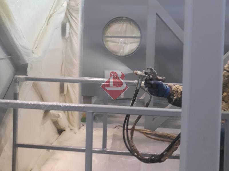 Tecnico applica l'isolamento in poliuretano a spruzzo su una struttura a Modena. Il poliuretano, utilizzato per migliorare l'efficienza energetica degli edifici, viene applicato con attrezzature specializzate per garantire una copertura uniforme e continua. La ditta Bertoni Isolamenti, leader nel settore, offre servizi di alta qualità per il comfort abitativo e la sostenibilità ambientale.