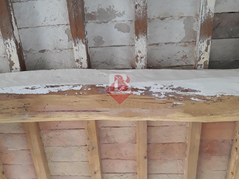 Travi in legno da restaurare in un edificio a Parma, pronte per un intervento di sabbiatura professionale per rimuovere vernice deteriorata e riportare il legno al suo stato naturale.
